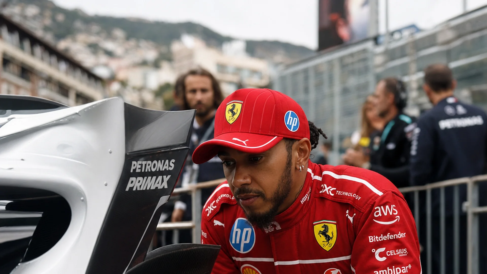 Lewis Hamilton bestudeert in Ferrari-tenue de zilveren Mercedes in de paddock van Monaco