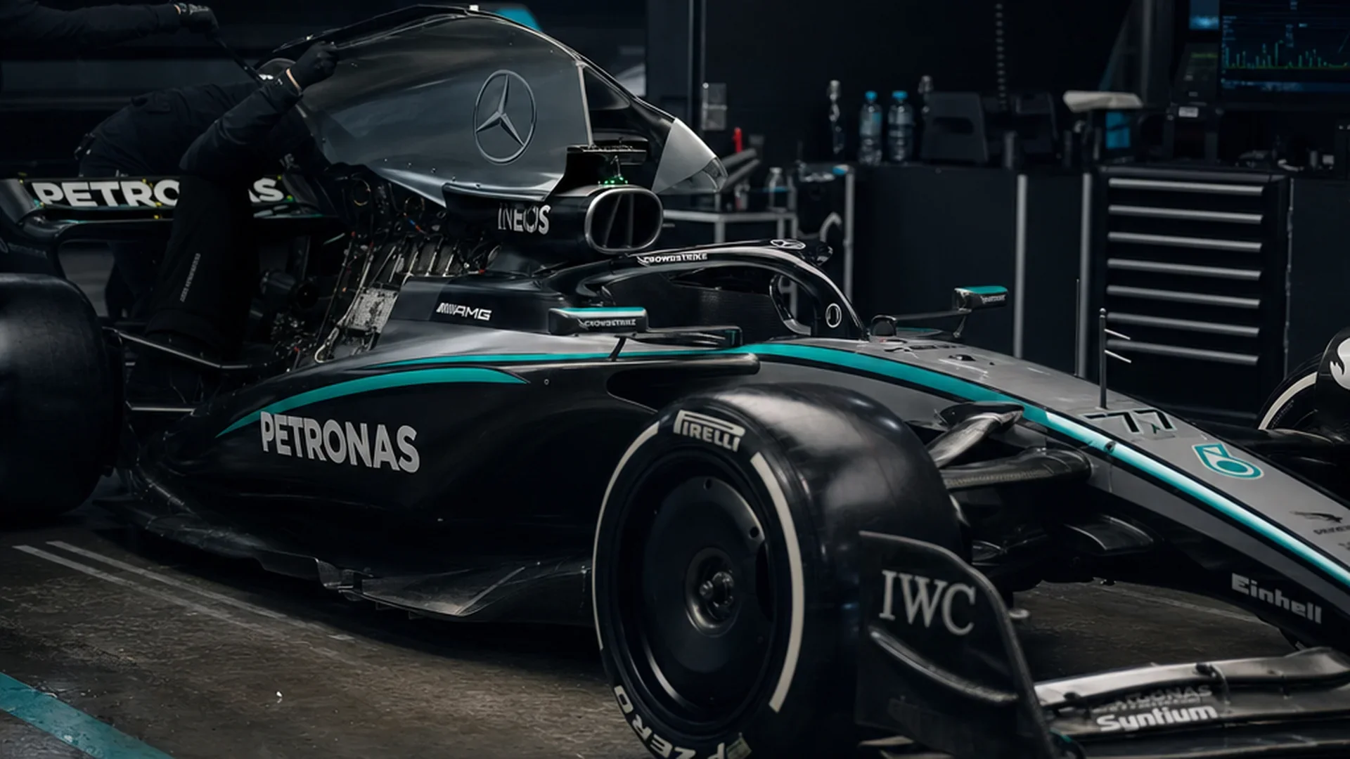 Monteur werkt aan de krachtbron van de Mercedes W17 met opgetilde motorkap in de garage