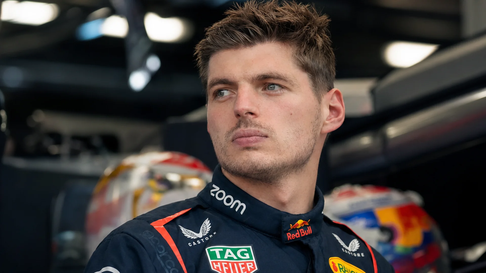 Max Verstappen kijkt peinzend voor zich uit in de Red Bull-garage