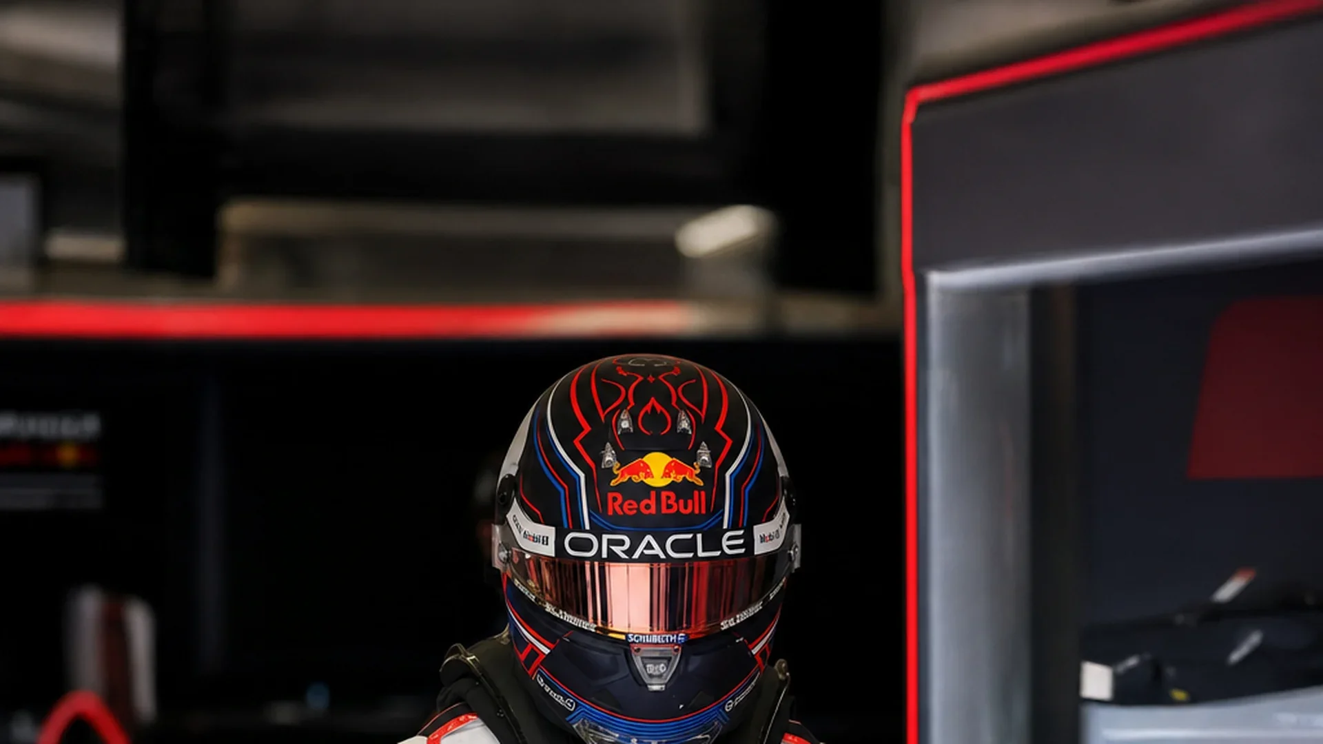 Max Verstappen met helm op en vizier dicht in de Red Bull-garage