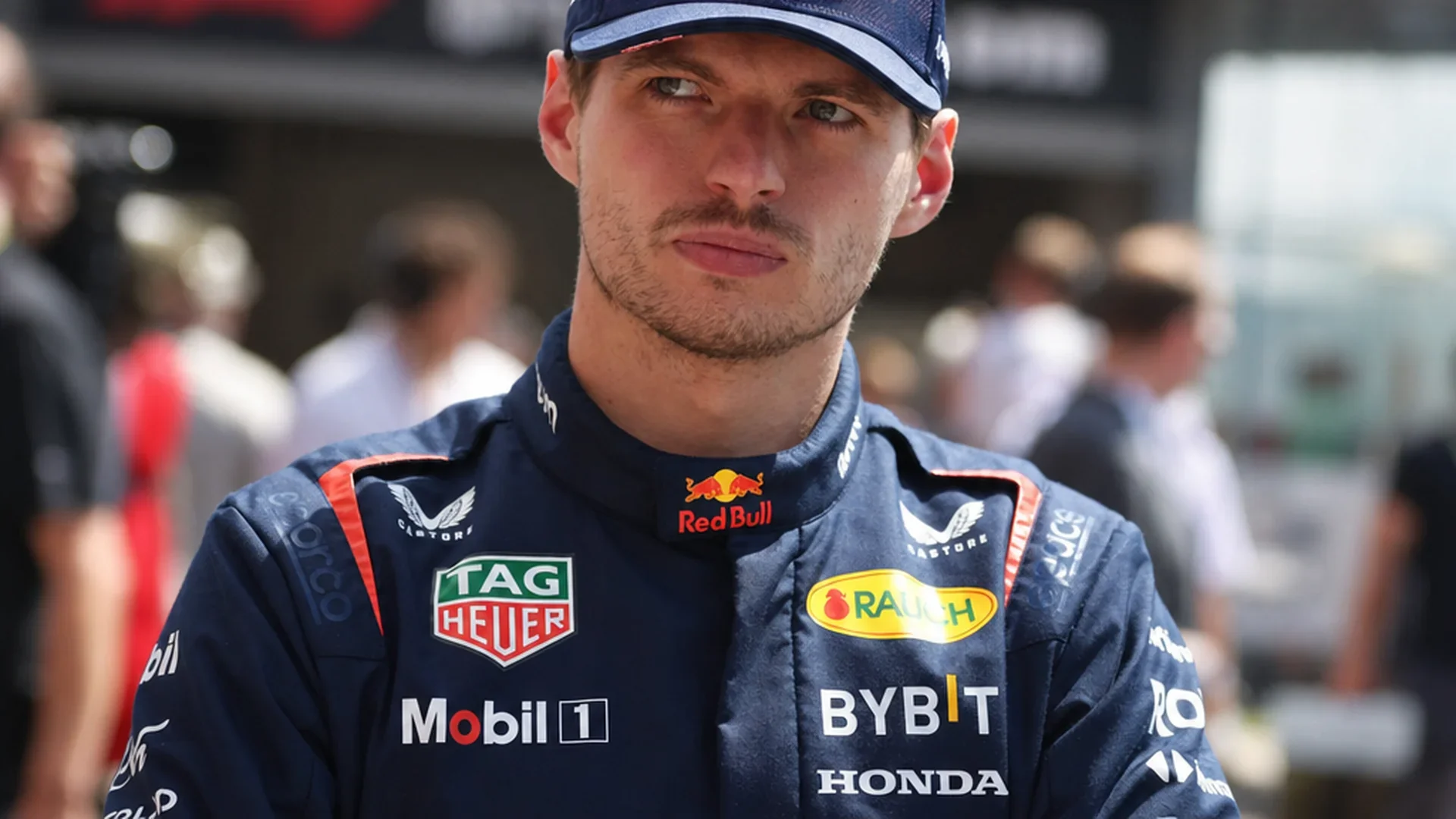 Max Verstappen in Red Bull-tenue met sceptische blik in de paddock van Barcelona