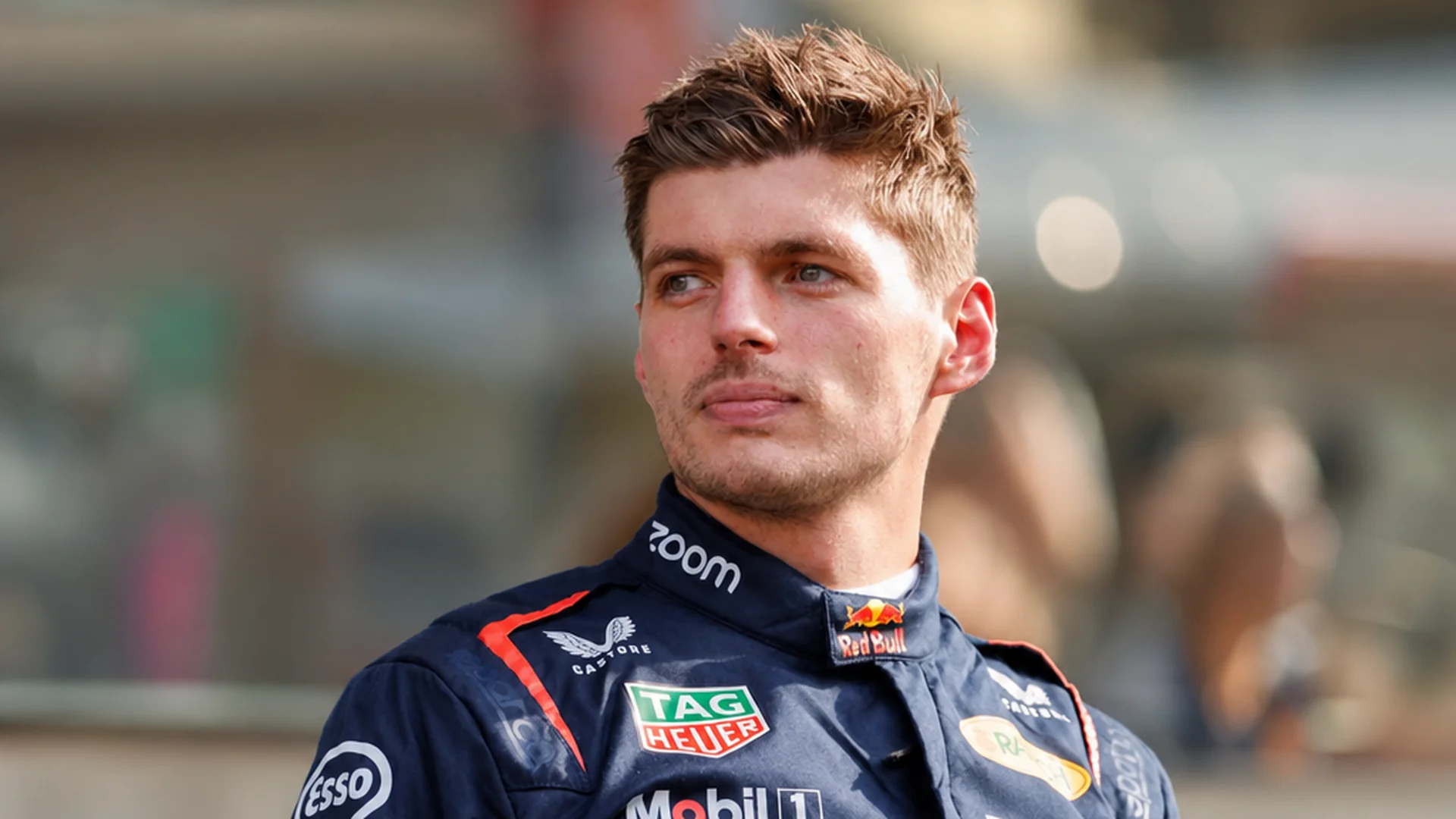 Max Verstappen in de paddock in zijn Red Bull-racepak